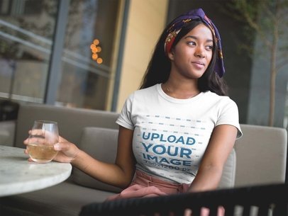 Pretty Woman Having a Drink at a Terrace While Wearing a T-Shirt Mockup