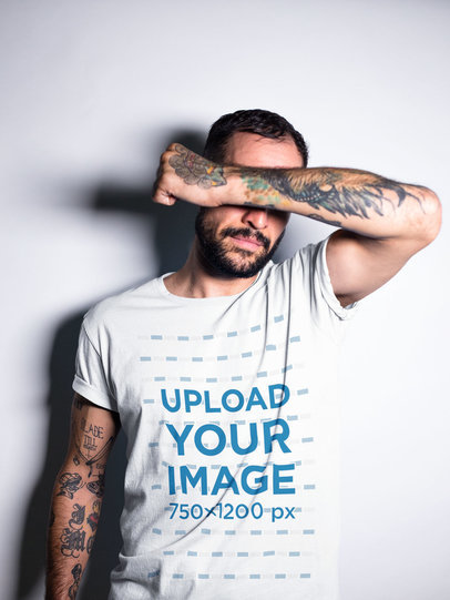 Tattooed Man Covering his Face While Wearing a T-Shirt Mockup