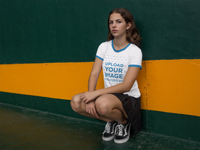 Woman Sitting Against a Wall While Wearing a Ringer Tshirt Mockup