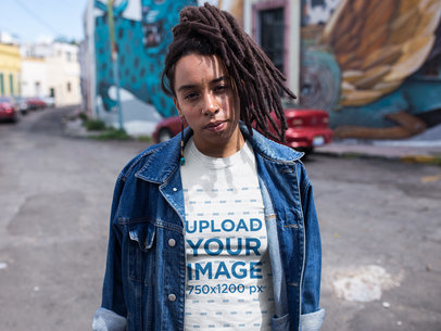 Woman with Dreadlocks Walking in the Middle of the Street Wearing a T-Shirt Mockup and a Denim Jacket a17139