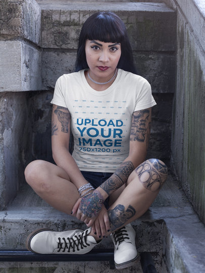Hispanic Tattooed Woman Wearing a Round Neck T-Shirt Mockup While Sitting on the Floor 