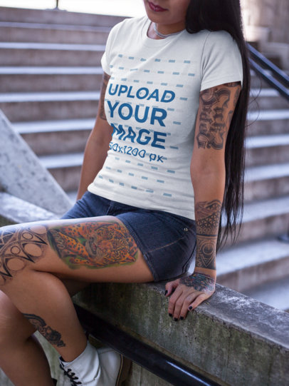 Tattooed Cropped Face Woman Wearing a T-Shirt Mockup Sitting Near Concrete Stairways