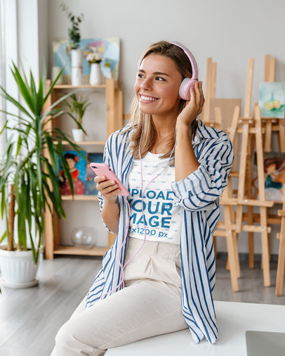 T-Shirt Mockup of a Woman Listening to Music in an Art Studio