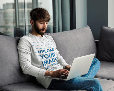 Long Sleeve Tee Mockup of a Man Working on His Laptop