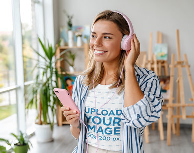 T-Shirt Mockup Featuring a Happy Woman Listening to Music 