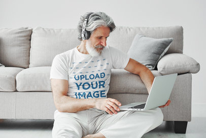 Round-Neck T-Shirt Mockup Featuring a Man Checking His Laptop