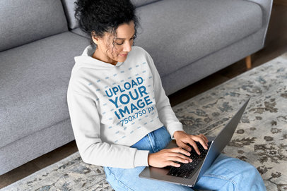Pullover Hoodie Mockup of a Woman at Home Working on Her Laptop 
