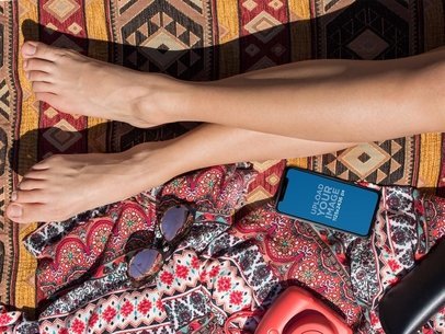 Mockup of an iPhone X Lying Next to a Sunbathing Womans Legs a17287