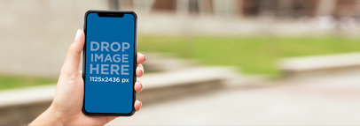 iPhone X Mockup Being Held While in the Suburbs Street a17292