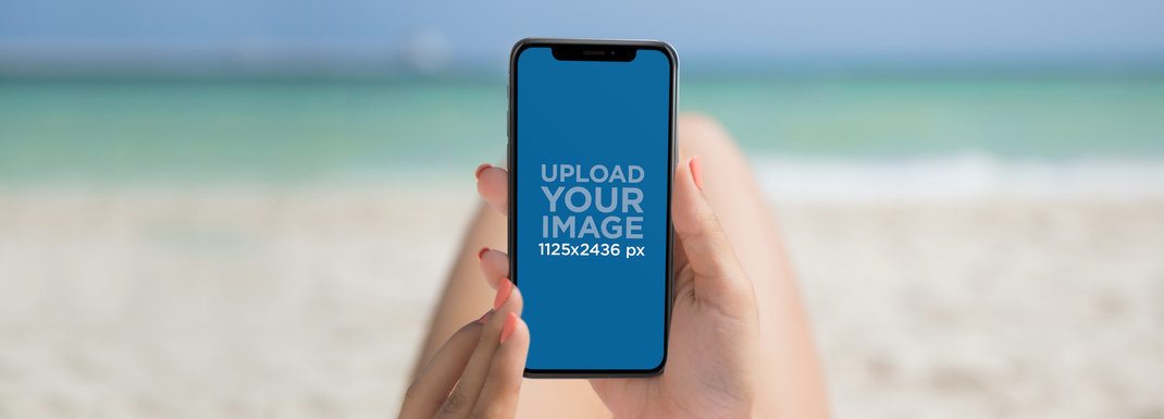 Woman Holding an iPhone 11 Pro Mockup while at the Beach