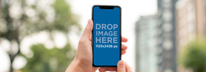 Mockup of an iPhone 11 Pro Being Held While in the City