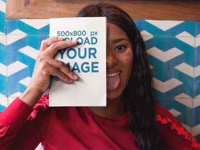 Mockup of a Woman Holding a Book Against her Face While Being Funny