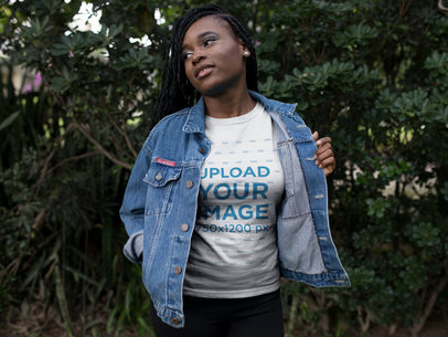 Mockup of a Woman Wearing a Round Neck Tee While Standing Against Plants 