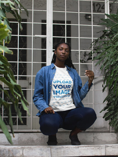 Woman Wearing a T-shirt Mockup While Crouching in a Building Entrance 17323