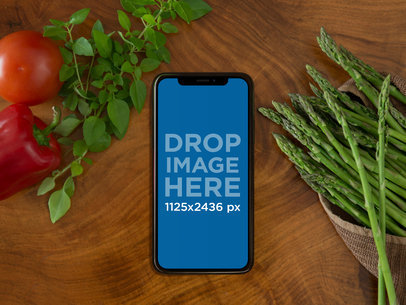 Mockup of a Space Gray iPhone X Lying on a Cooking Table a17382