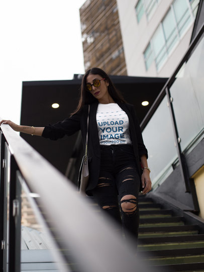 Pretty Fashion Woman Wearing a T-Shirt Mockup While Going Down the Stairs