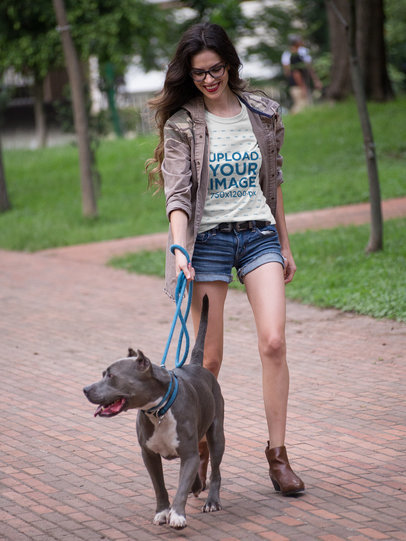 Pretty Woman Walking the Dog Wearing a T-Shirt Mockup at the Park