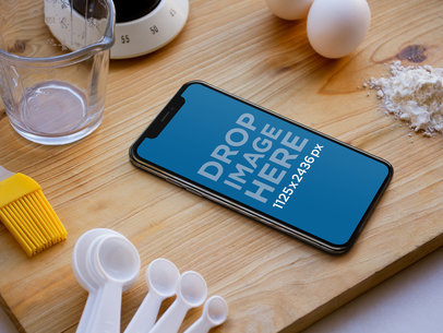 iPhone X Mockup Lying on a Kitchen Counter Near Supplies a17396
