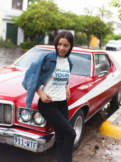 Beautiful Woman Wearing a Round Neck Tee Mockup While Lying Against a Muscle Car