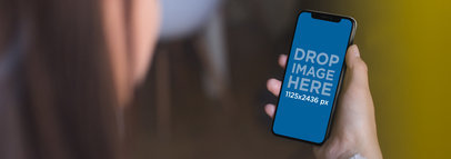 Woman at a Coffee Shop Using her iPhone 11 Pro Mockup