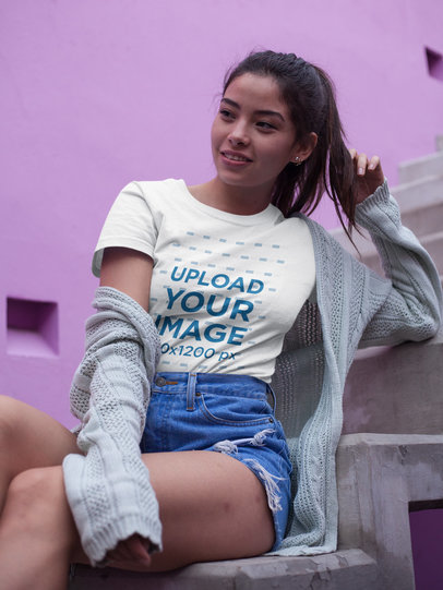 Beautiful Woman Wearing a T-Shirt Mockup While Sitting on Concrete Stairways