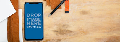 iPhone X Mockup Lying on a Space Work Near Pencils and Leather Strips a17507