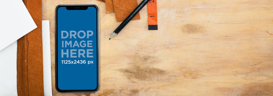 iPhone 11 Pro Mockup Lying on a Space Work Near Pencils and Leather Strips