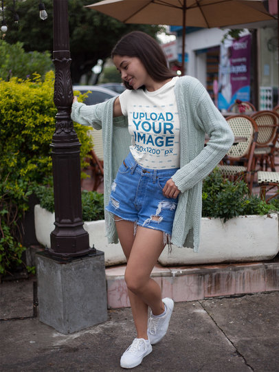 Happy Woman Wearing a Tee Mockup While Outside a Coffee Shop