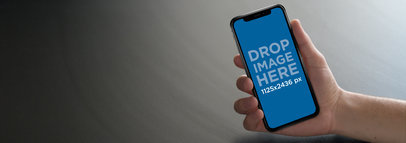 iPhone 11 Pro Mockup Being Held Against a Flat Gray Backdrop