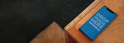 Mockup of an iPhone 11 Pro on a Wooden Desk
