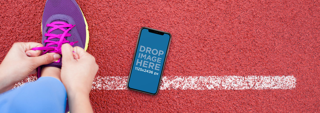 iPhone 11 Pro Mockup Lying on a Running Track Next to a Person