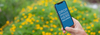iPhone 11 Pro Mockup Being Held While Against a Flowers Garden
