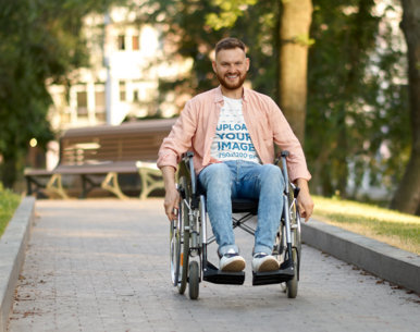 T-Shirt Mockup of a Man Using a Wheelchair at a Park