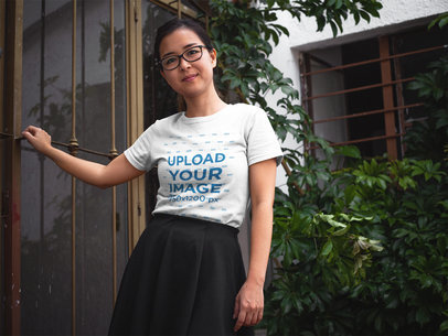 Asian Girl Wearing a Round Neck T-Shirt Mockup While Against Plants a17601