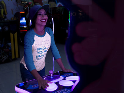 Beautiful Woman Wearing a Tshirt Mockup While Playing an Arcade Game