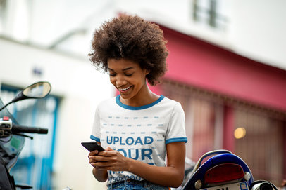 Mockup of a Woman With a Ringer T-Shirt Reading a Funny Text Message