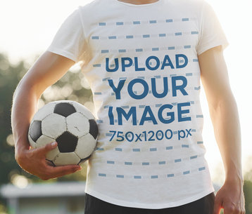 Round-Neck T-Shirt Mockup of a Man Holding a Soccer Ball