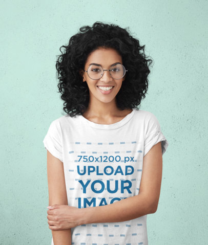 T-Shirt Mockup Featuring a Woman With Glasses Against a Wall