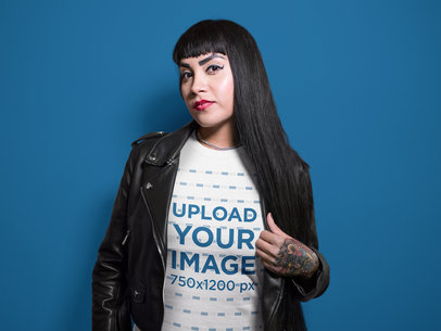 Tattooed Woman Wearing a T-Shirt Template and a Dark Jacket Against a Solid Surface