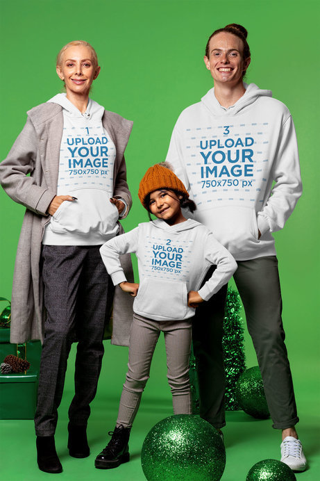 Winter Wear Mockup of a Family Wearing Hoodies and Posing at a Studio with Christmas Decorations 