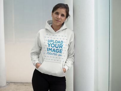 Woman Wearing a Pullover Hoodie Mockup While Lying Against a Metal Column