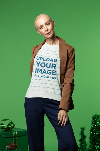 Xmas-Themed Sweatshirt Mockup Featuring a Senior Woman Posing at a Studio
