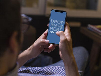 iPhone X Template Being Used by Man While Lying on the Sofa a17776