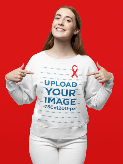 Sweatshirt Mockup of a Happy Woman Pointing at Her Red Ribbon for AIDS Awareness