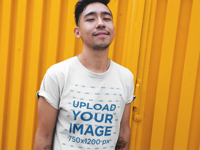 Man Wearing a Round Neck Tshirt Mockup While Standing Against a Yellow Wall