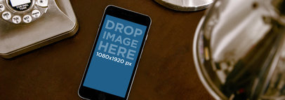 Wide Mockup of a Black iPhone 6 on a Vintage Desk