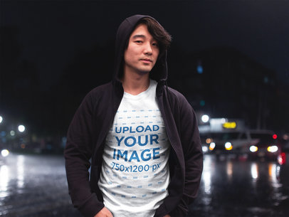 Asian Man Wearing a T-Shirt Mockup While on the Street at Night