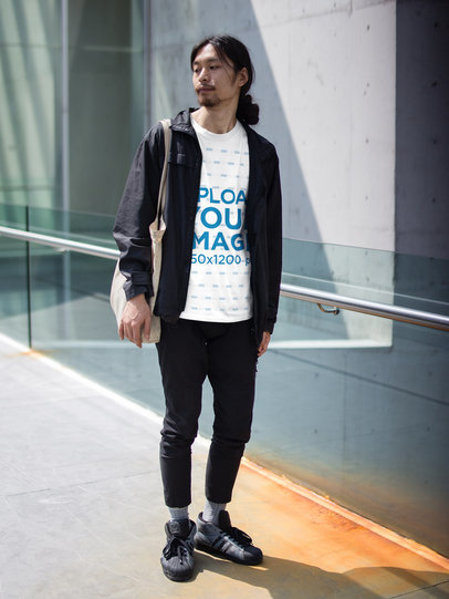 Guy Wearing a T-Shirt Mockup While Carrying a Tote Bag Outdoors