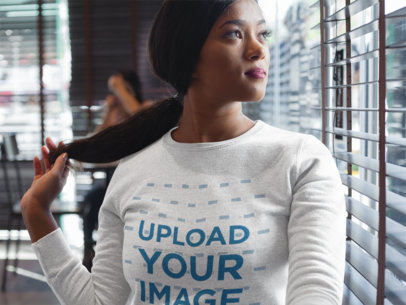 Woman Wearing a Crew Neck Sweatshirt Template While Looking Through the Window