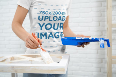 T-Shirt Mockup of a Woman Painting a Piece of Furniture